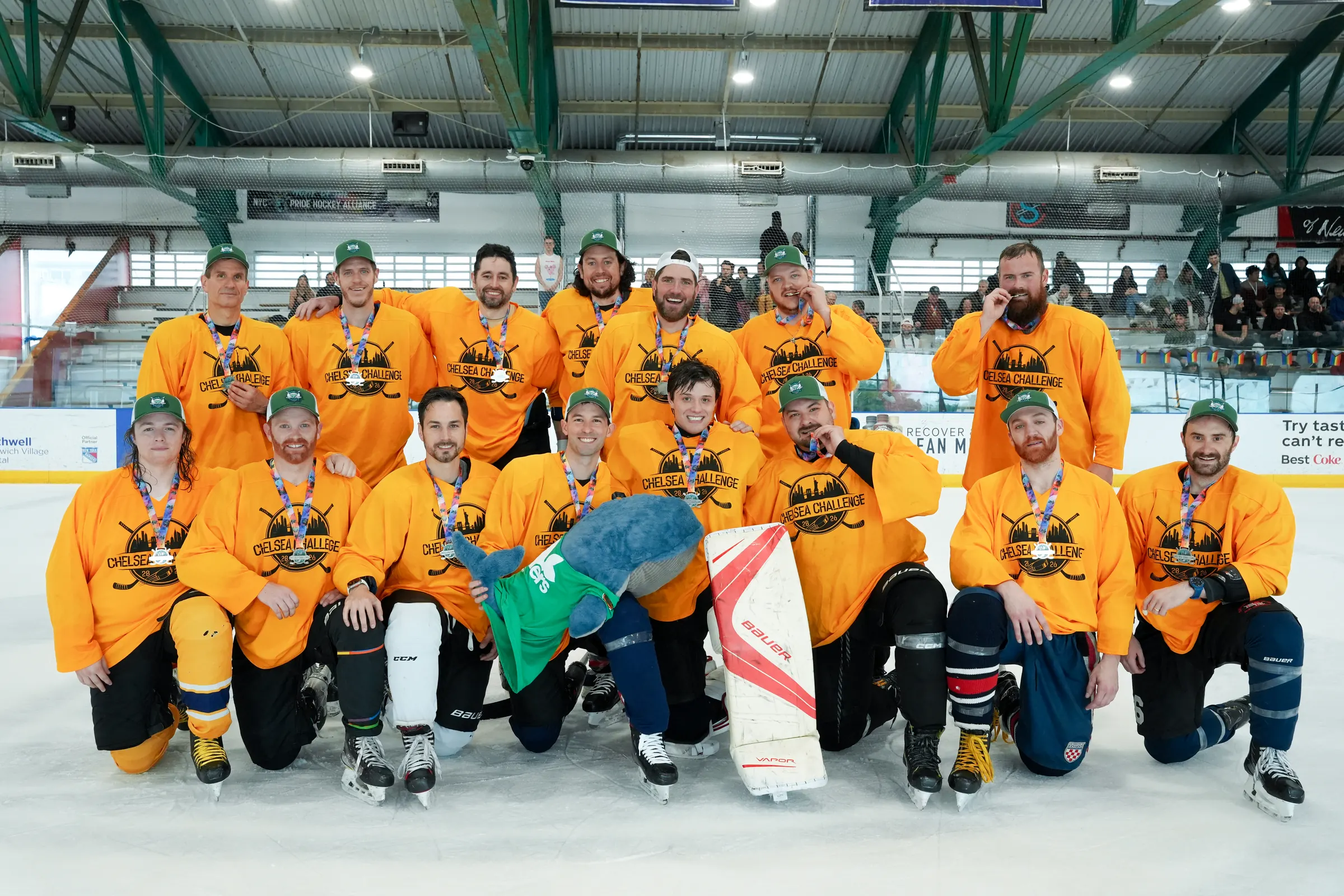 The Whale Tailers team photo on the ice in yellow jerseys, with Boris the Whale in the front row